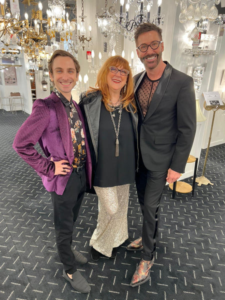 Robin Baron with guests at the lighting showroom, many fixtures visible.